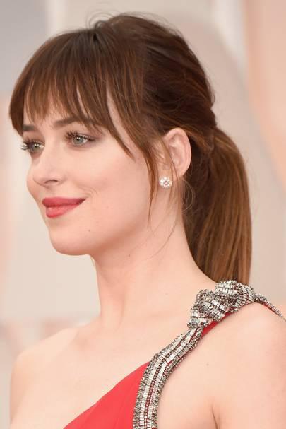 Dakota brilló en los Oscar de 2015 con un atrevido vestido rojo y una sencilla cola de caballo recta.: 